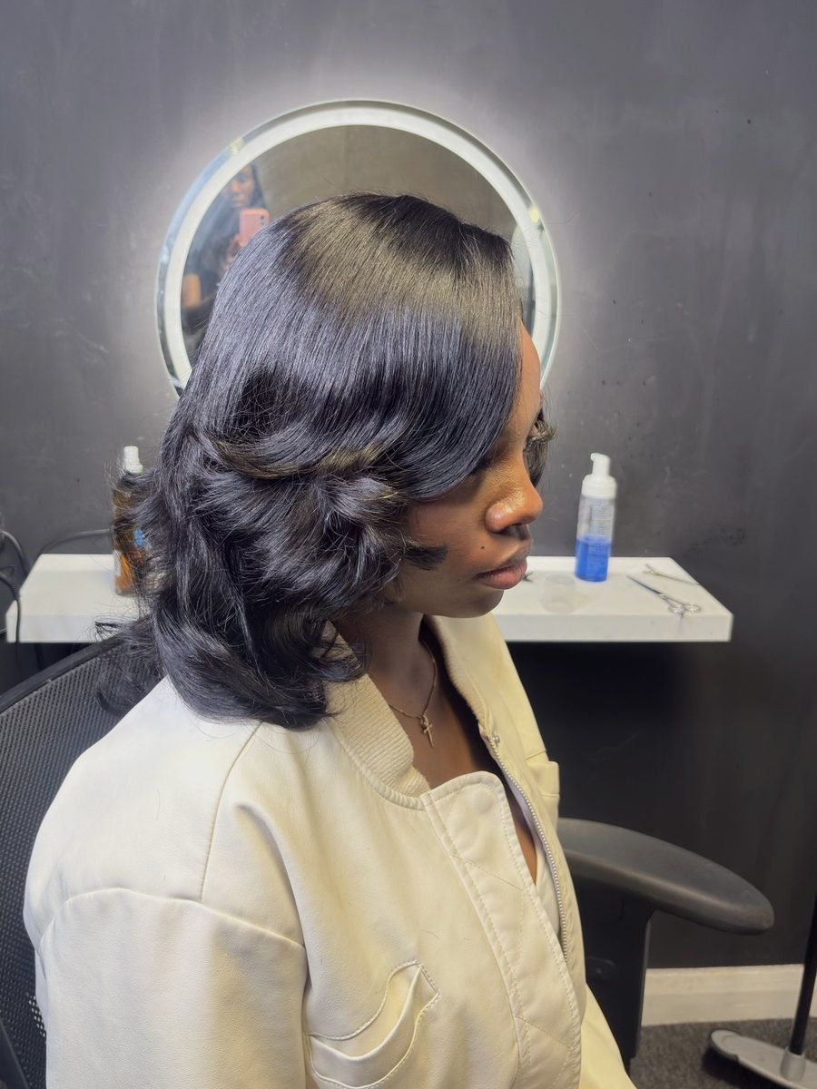 Side profile of a bouncy, curled mid-length sew-in
